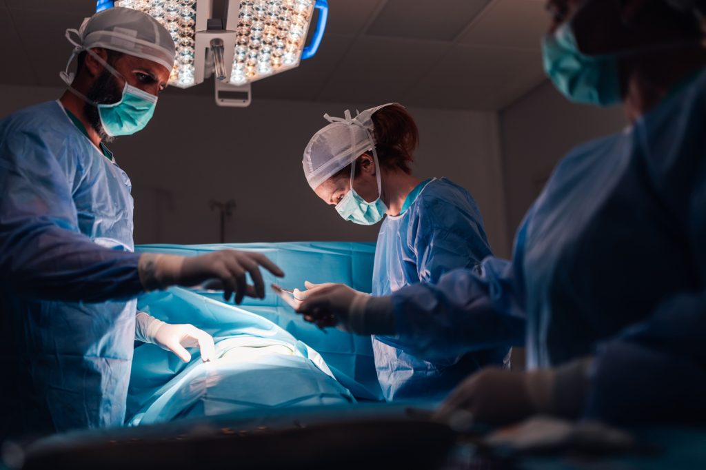Doctors at work during a surgery, coordinated and attentive to details.